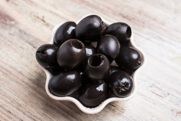 Black olives on a wooden background