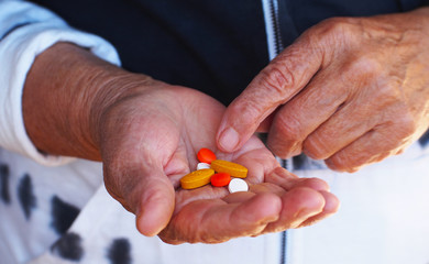 Close up shot of a hand holding several medicines.