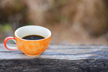 Black coffee in cup on timber wood.