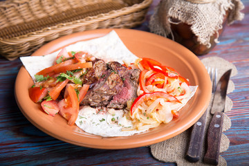 Grilled meat sliced with vegetables.