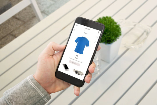 Shopping clothes with smart phone. Modern online market app on black mobile screen.
