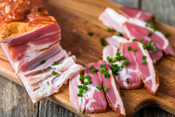 Smoked bacon on wooden table, pork meat.
