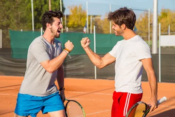  Two friends standing on tennis court and encouraging each other before match.   © pablobenii
