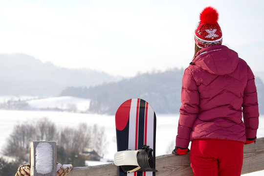winter, leisure, sport and people concept - happy young woman in red hat outdoors