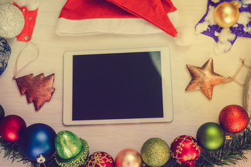 Top view of tablet computer and Christmas decor on wooden background. Mock up closeup photography. Modern technology connection, shopping delivery service, social network, festive happy busy time