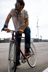 modern man rides a fixie bicycle in the street	