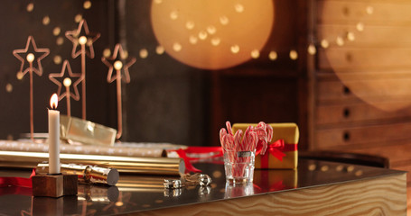 Beautifully wrapped Christmas presents on the background of stylish decorations and lights in warm golden and red tones