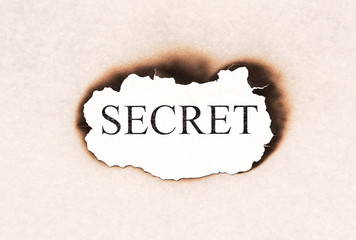 Secret revealed word text appearing behind burned paper