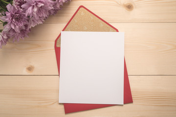 Red envelope and  flowers on wooden background  	