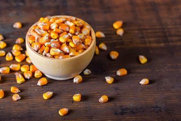 Close up corn seeds in bowl on wooden table