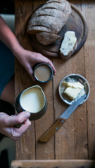 Top view woman has breakfast adds milk to coffee