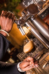 Waiter pours beer in a pub