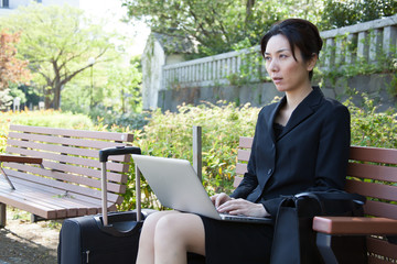 Japanese Business Woman Uses Laptop Outside