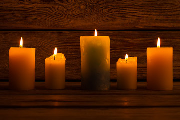 Lighted candles on wooden background.