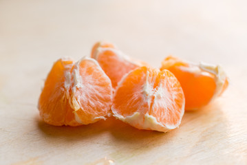 Closeup pieces of peeled tangerine on wooden board