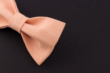 Bow tie with beige color on a black background