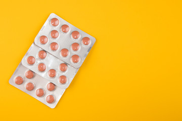 Tablets in a package on a yellow background