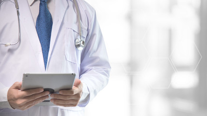 Doctor hold the tablet in his hand with blur white bokeh and group of hexagon on background, medical and technology concept