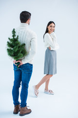 man surprising girlfriend with christmas tree