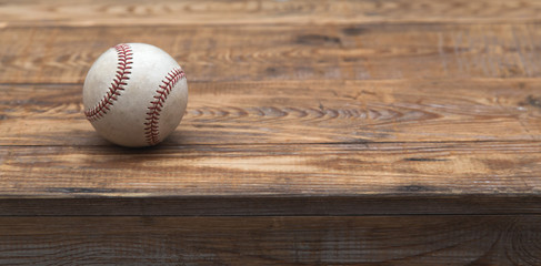 Baseball on a old rustic wooden desk with partial blur background