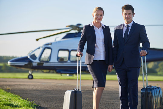 Portrait Of Businesswoman And Businessman Standing In Front Of Helicopter