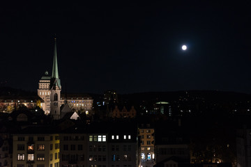 Fototapeta na wymiar zurich city by night with full moon shinging and light on buildings