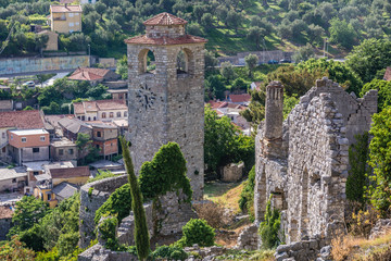 Fototapeta na wymiar Renovated tower clock among ruins of Stari Bar fortress near Bar city in Montenegro