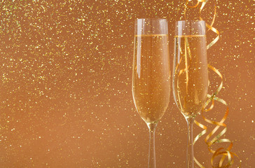 Champagne flutes on golden holiday background