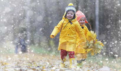 Toddlers on a walk in the autumn park. First frost and the first