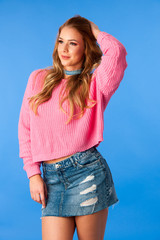 cute young woman inpink sweater over blue background 