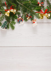 Naklejka na ściany i meble Fir tree twigs and new year ornaments border at white wooden background