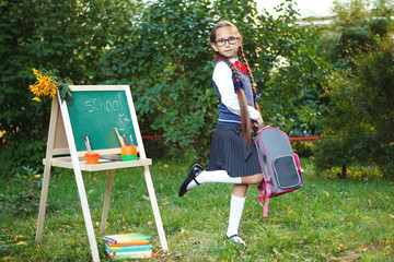 A beautiful little girl, a schoolgirl in a Park beside the school Board. - Powered by Adobe