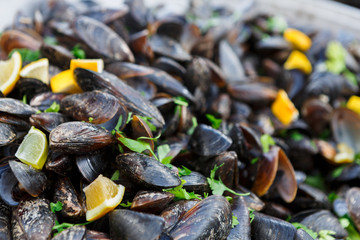 Fresh mussels on grill with greens