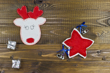 White deer and star of felt on wooden texture.