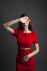 Pretty young sexy model female with dark hair in amazing red dress