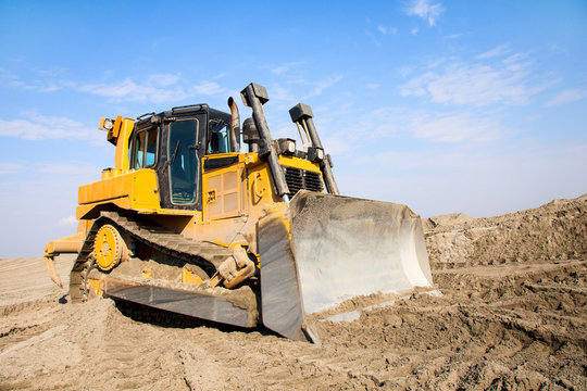 The bulldozer works on a sandy quarry.
