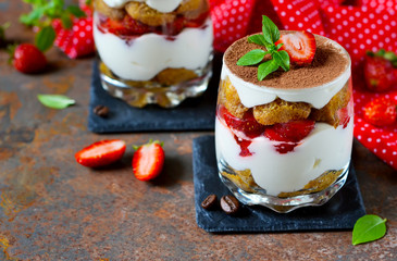 Italian dessert tiramisu with strawberries on an old grunge background