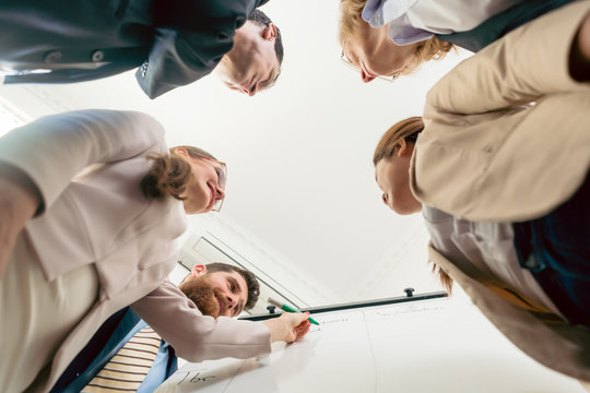 Low-angle view of an international team working together during brainstorming session