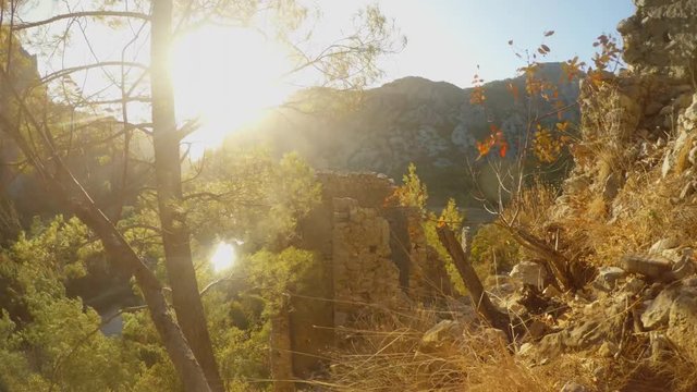 ruins of the ancient Lycian city of Olympos in the bright sunshine, reflection in the water and mountains