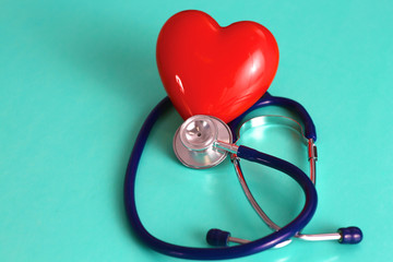 Red heart and a stethoscope on desk