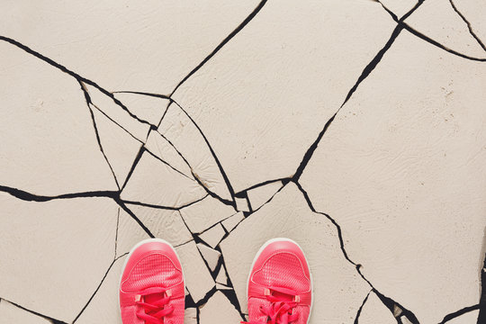Pink shoes on cracked floor copy space