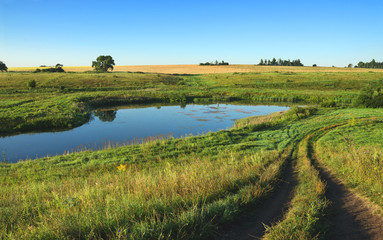 Sunny summer landscape.River Upa in Tula region,Russia.Ground country road in the meadows.