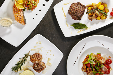 Set of main dishes with fish, meat and vegetables with greens fried on grill