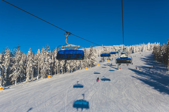 Beautiful cold mountain view of ski resort, sunny winter day with slope, piste and ski lift
