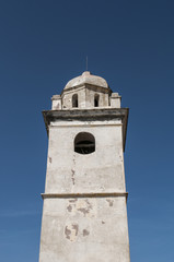 Fototapeta na wymiar Capo Corso, Corsica, 28/08/2017: il campanile bianco di Canari, un ex faro costruito per segnalare la costa ai marinai nel paese noto come il villaggio dei cento capitani