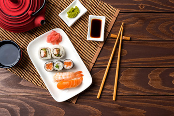 Set of sushi with red teapot and chopsticks