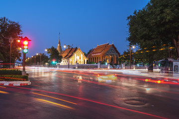 Buddhist temple of Wat Pra Tard Chang Kum in Nan, Thailand with trafic jam at night scene.