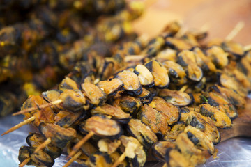 Mussel barbeque on a stick, seafood at a street market