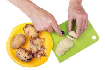 Chef elderly grandpa  with a knife and hands is cut potato into round pieces.