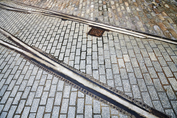 Old tram tracks on cobblestone background.